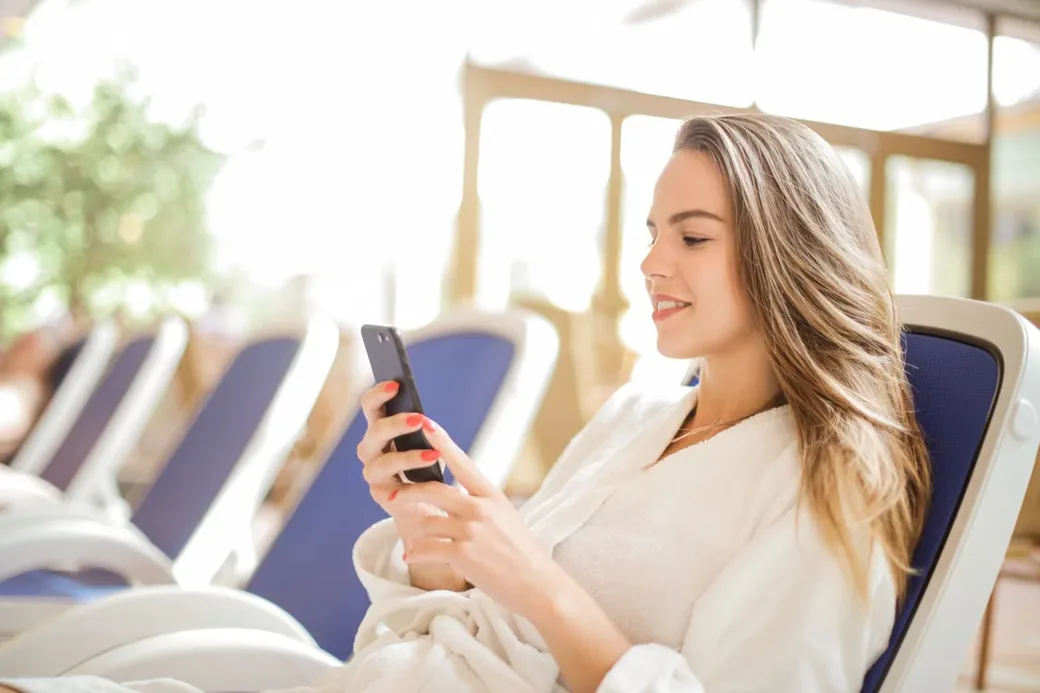 Chủ spa thư thái mỉm cười nhìn điện thoại