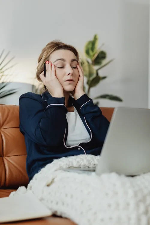 Chủ spa mệt mỏi vào buổi tối bên laptop